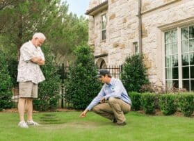Weedex technician speaking with a customer about their lawn treatment service