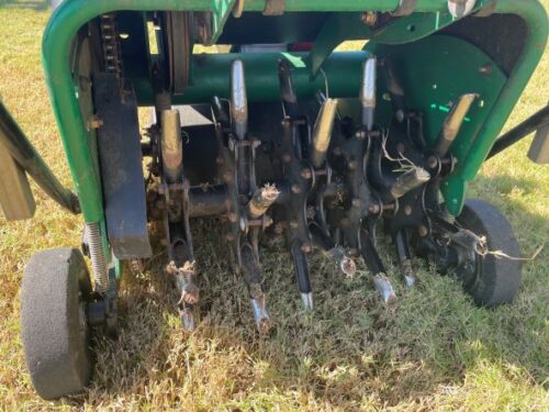 underside of lawn core aeration machine showing the core pulling spikes