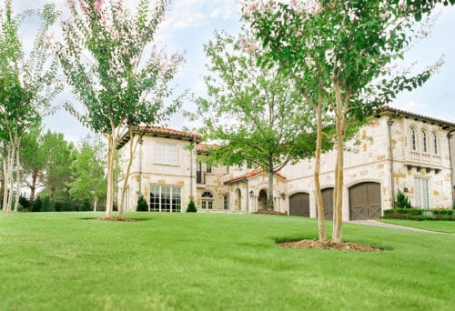 Spanish style house with lawn with green grass and trees